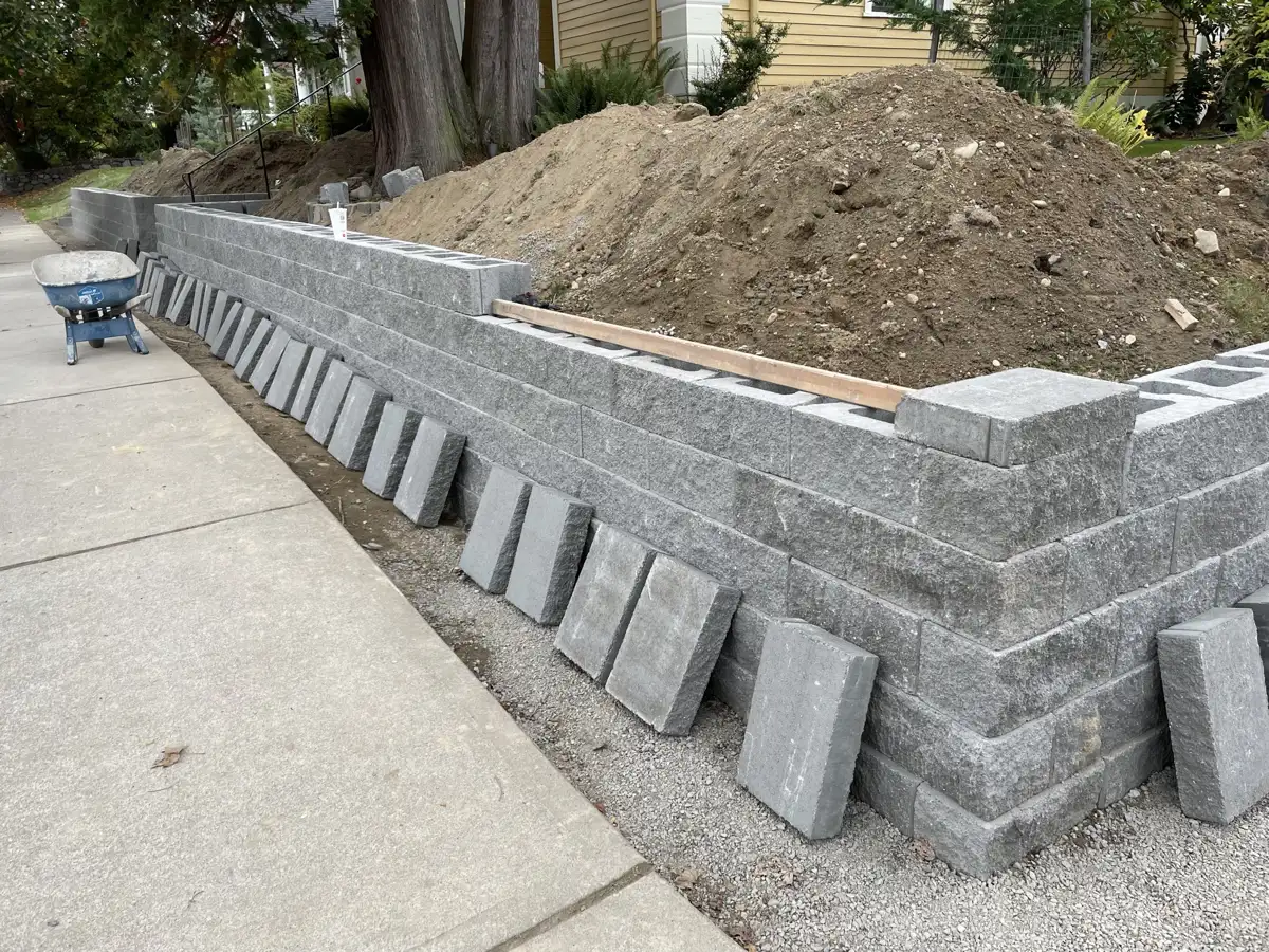 Wall built up and backfilled, caps staged for install