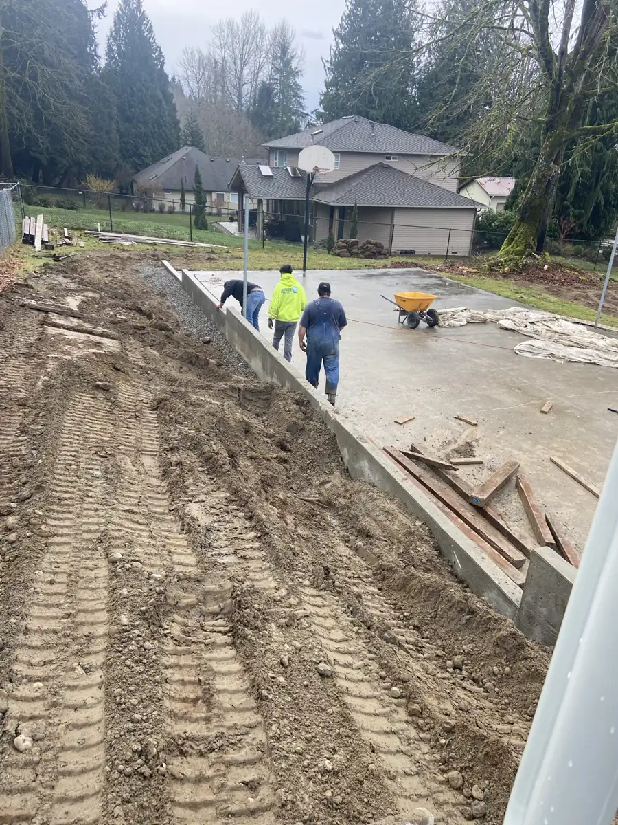 Grading and forming beside a new concrete slab