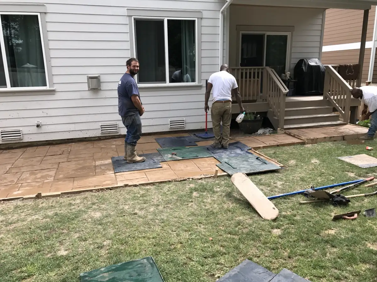 Pulling stamp mats on a decorative concrete patio